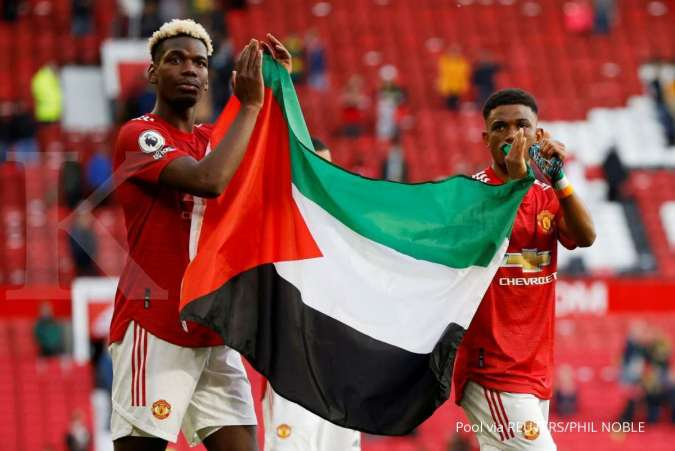 Paul Poga (kiri) mengibarkan bendera Palestina