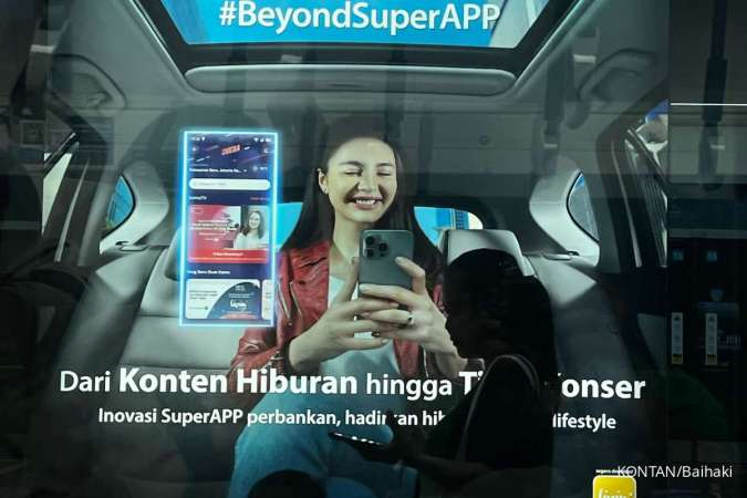Transaksi Digital: Pejalan kaki melintas depan iklan Livin by Mandiri 