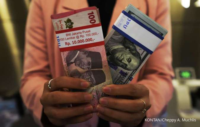 Rupiah Melemah-Petugas menghitung uang Rupiah dan Dolar Amerika Serikat